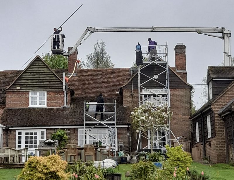 The Moss Cleaners using cherry picker and scaffolding to clean roof safely and professionally in Bagshot, Surrey